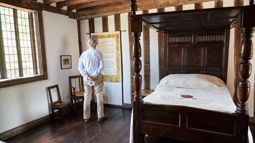 Visitor in the bedroom at Paycocke's House and Garden, Essex
